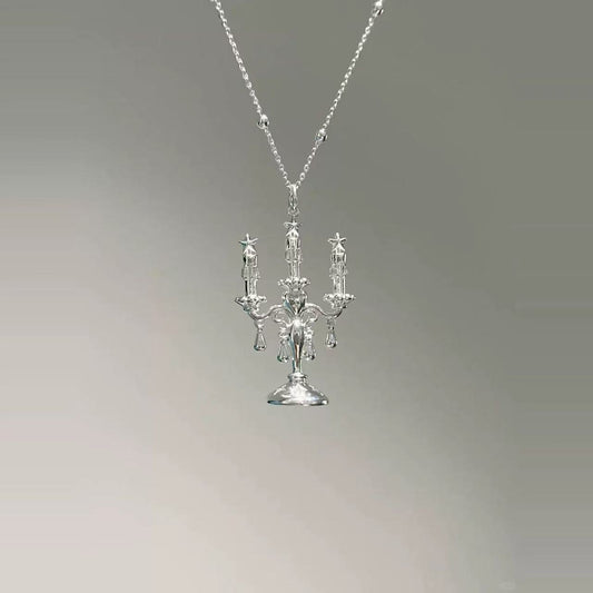 The Trendy Candles Decor Style Necklace, made from Sterling Silver 925, showcases a pendant shaped like an ornate candelabra with three candle-like arms, set against a plain gray gradient background.